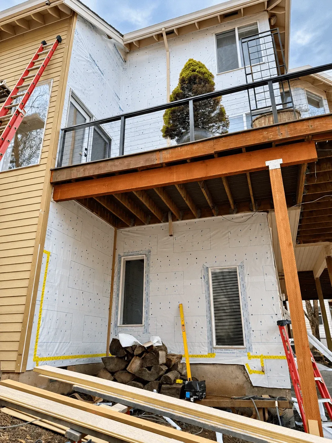Deck framing and house wrap on a two-story home during a rebuild