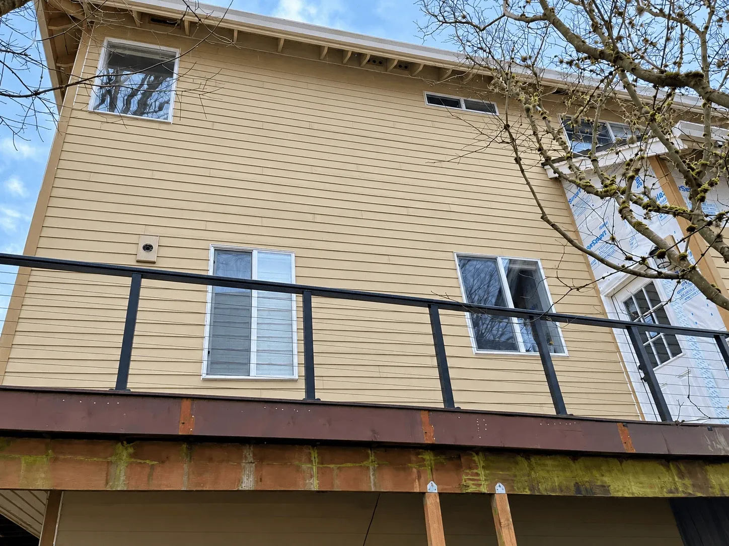 Upper deck railing and ledger on a tan-sided home