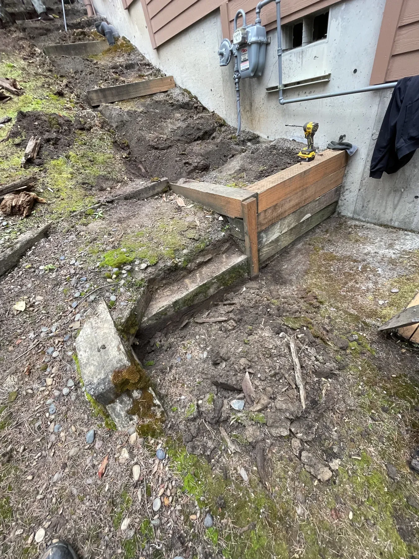 Early retaining wall framing at the base of the outdoor stairs