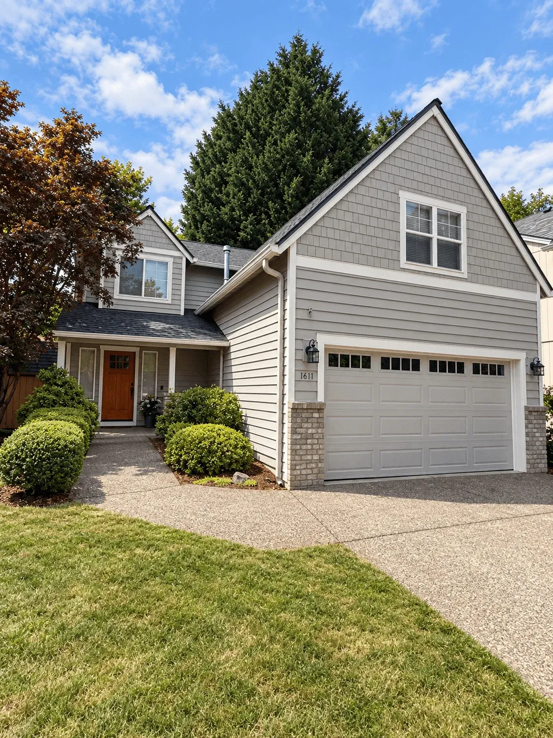 Finished gray lap siding and shake gable over a two-car garage