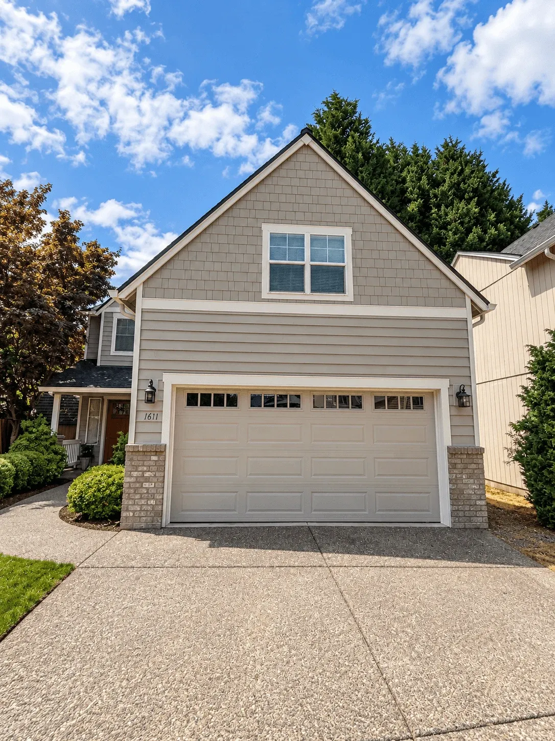 Gray lap and shake siding on a garage gable with white trim