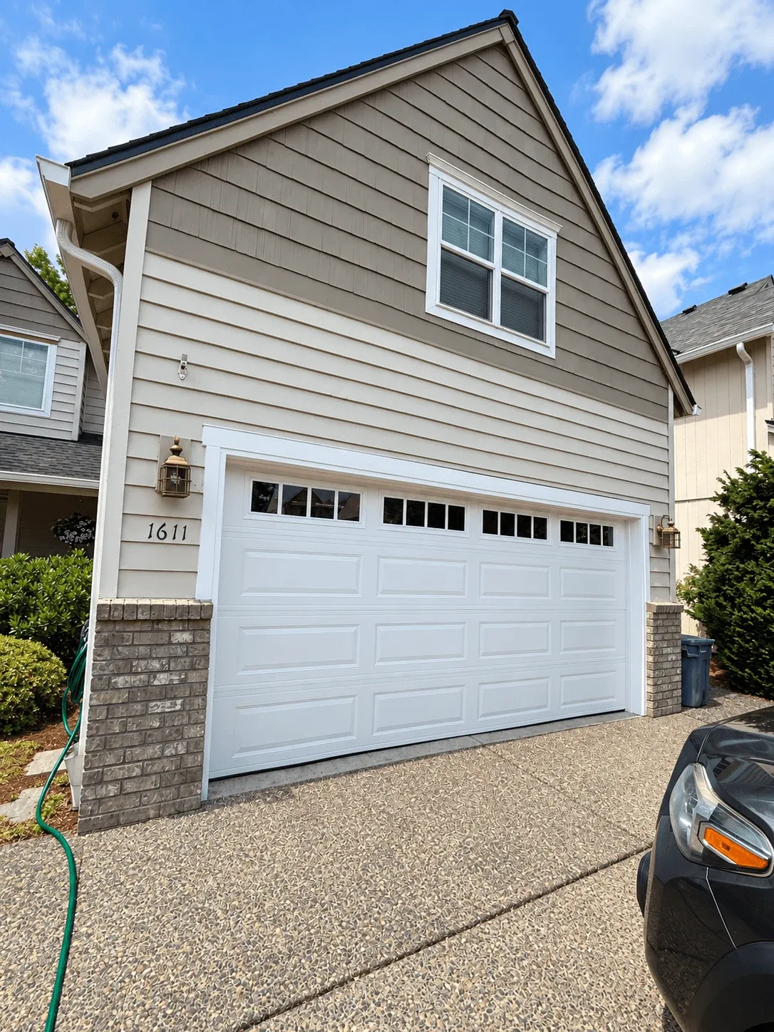 New lap siding and shake gable above a white garage door