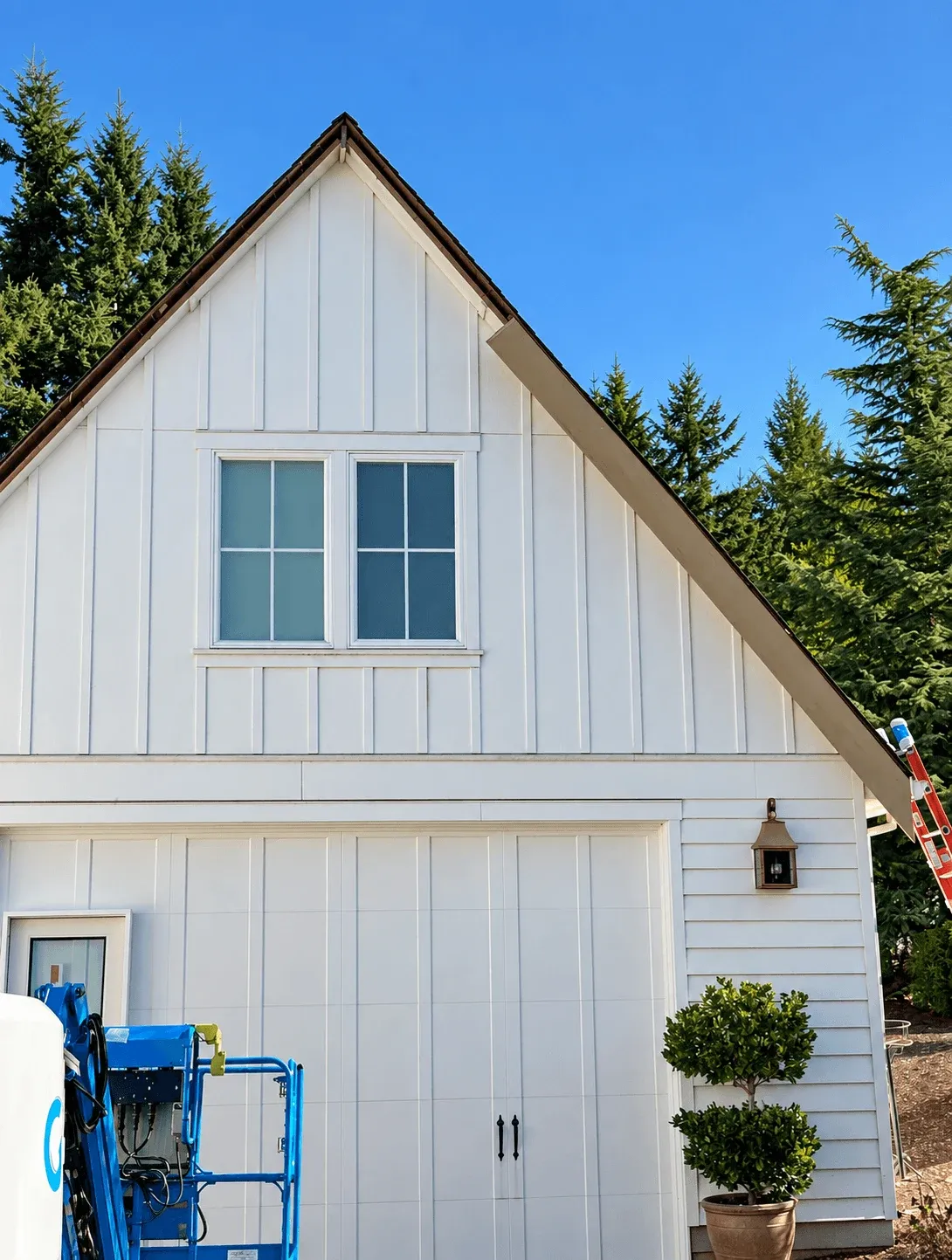 White board-and-batten gable over a carriage-style garage door